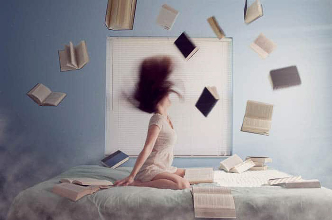 تصویری مفهومی از دختری در اتاق خوابش که توسط کتابهای پرنده احاطه شده است